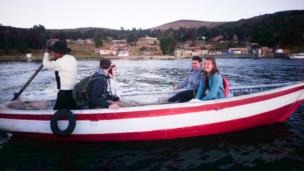 "Turistas con Pescador artesanal en bote sobre el Lago Titicaca"