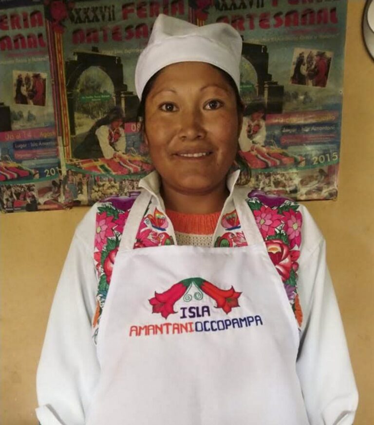 Cocinera chef de isla Amantani con Turistas cocinando con quinoa en taller de cocina tradicional